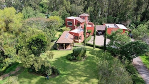 A residential property with multiple buildings, a well-maintained lawn, and surrounding greenery.