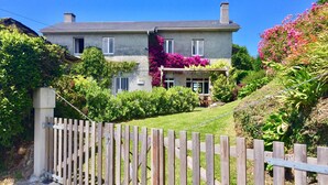 A two-story house with a wooden fence in front. - Perfectly located summer cottage, just a stone's throw from 5 pristine beaches! (Ortigueira)