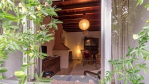 A traditional interior with a wooden ceiling, a hanging paper lantern, and a view of a garden through a glass door. - Perfectly located summer cottage, just a stone's throw from 5 pristine beaches! (Ortigueira)