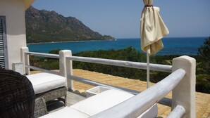 Ein Balkon mit Blick auf Meer und Berge.