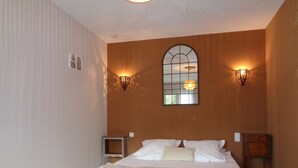 A bedroom with a large bed, two wall sconces, a mirror, and a window. - Bed & Breakfast in a Farmhouse- air conditionned - Lacoste (Lacoste)