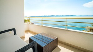 A balcony with a view of the sea, a wicker table, and a chair. - Stunning private villa for 12 guests with hot tub, private pool, WIFI, A/C, TV and patio (Zadar)