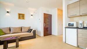 A modern living room with a sofa, a coffee table, and a kitchen area with cabinets and appliances. - Stunning private villa for 12 guests with hot tub, private pool, WIFI, A/C, TV and patio (Zadar)