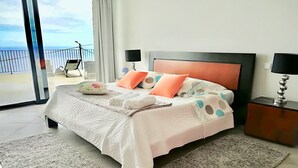 A hotel room with a large bed, two nightstands, a view of the balcony, and a large window. - Syso House - Extraordinary ocean view ----- (New Promotions) ----- (Arco da Calheta)
