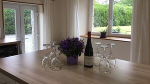 Uma bancada de cozinha com copos de vinho, uma garrafa de vinho e um vaso de planta.