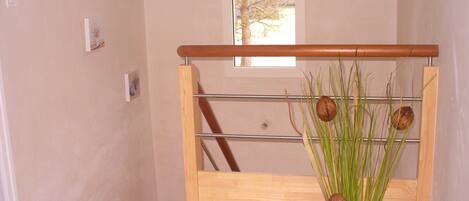 A wooden bench with a metal frame, a glass window, and a vase with green plants and nuts.