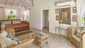 A spacious living area with a high ceiling, a wooden ceiling, a bed, a sofa, a coffee table, and a side table. - Luxury 6 Bed Villa With Pool, Mullins Bay (Mullins)