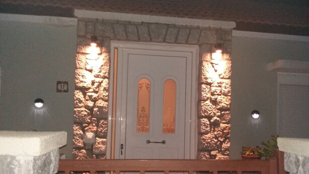 A stone facade with a white door featuring a decorative glass panel.