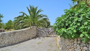 A stone wall with a gate leading to a paved path.