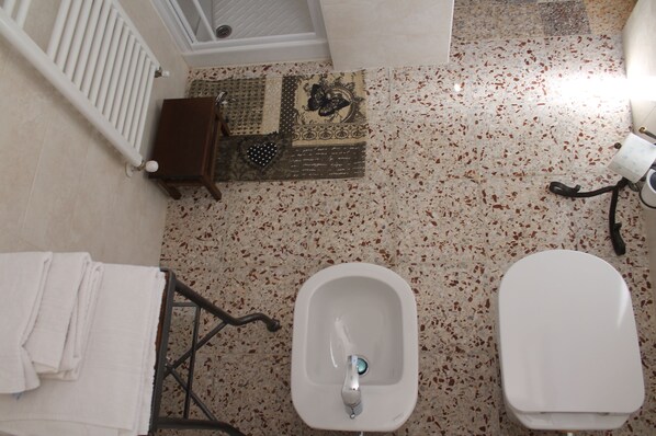 A bathroom with a bidet, a toilet, a towel rack, and a small wooden cabinet. - Country stay in Siena: a real, unique medieval experience in apartment for 2 (Siena)