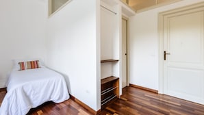 Un dormitorio con cama, armario y puerta.