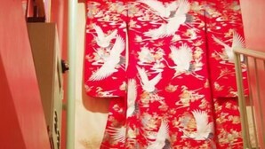 A staircase leading to a room with a red curtain featuring white birds. - Kichinan - Hostel (Osaka)