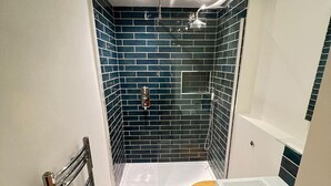 A bathroom with a shower, toilet, and bathtub.