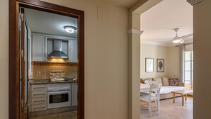 Una cocina con estufa, horno y microondas, y un comedor con mesa y sillas.
