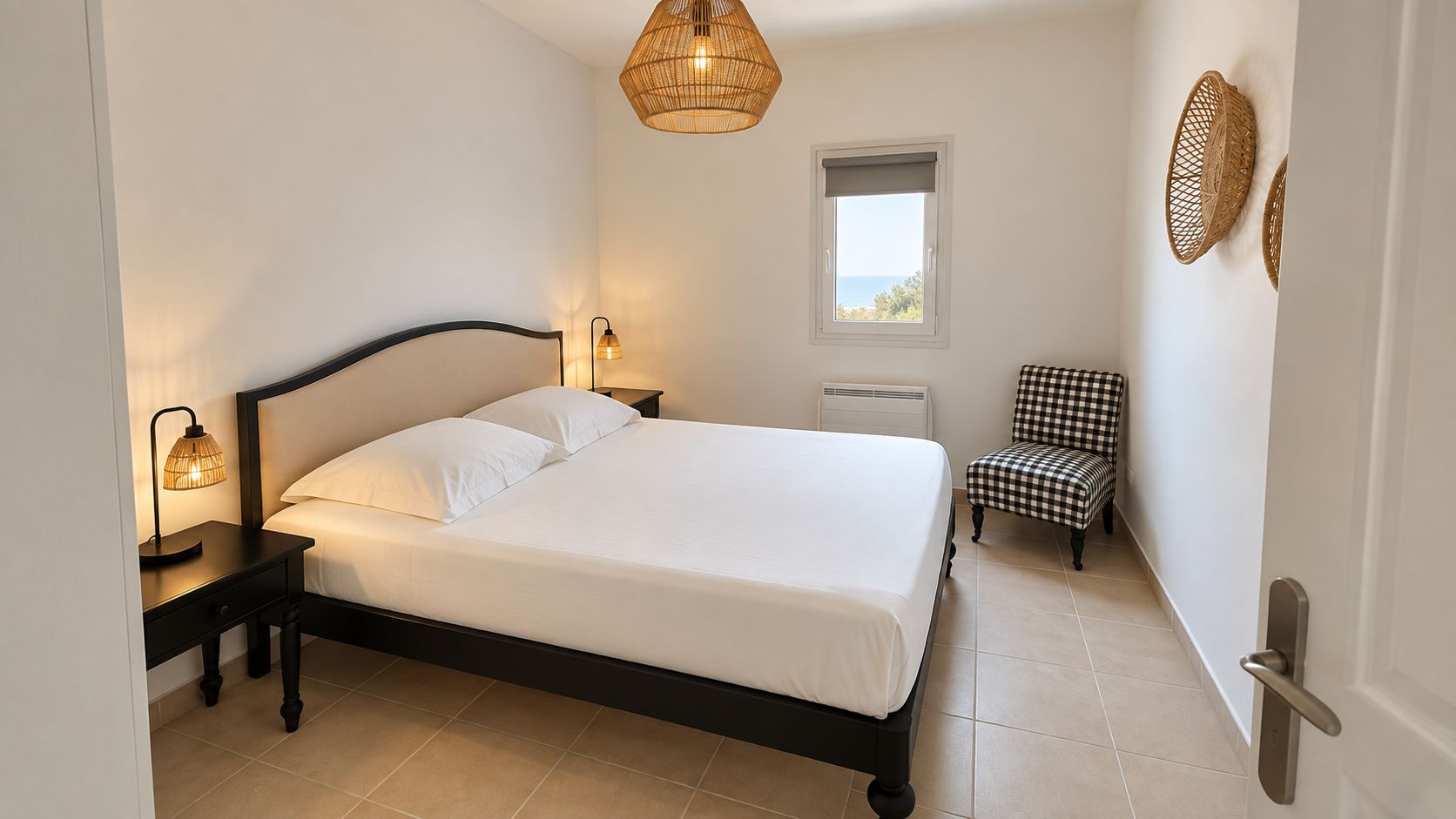 Une chambre à coucher comprenant un lit, des lampes de chevet, une chaise, une fenêtre et un luminaire fixé au mur.