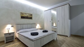 Un dormitorio con cama, mesitas de noche, un espejo y un armario.