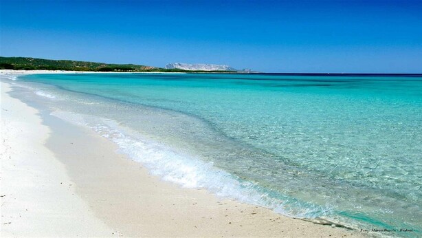 A beach with clear turquoise water and white sand.