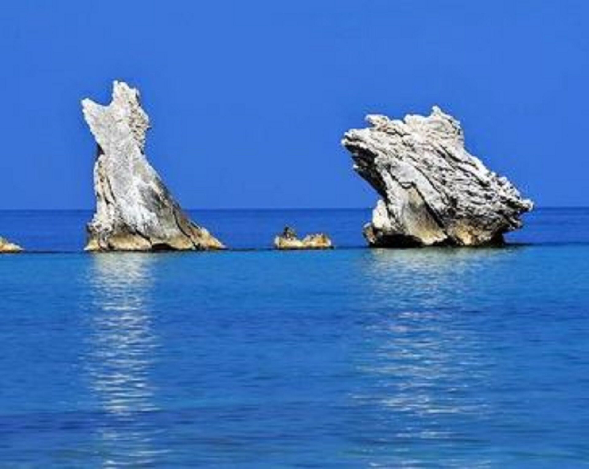A coastal scene with large rock formations emerging from the water.