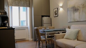 Una cucina moderna con zona pranzo, divano e un grande quadro astratto.