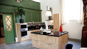 Una cocina moderna con armarios de madera, una isla central, electrodomésticos de acero inoxidable y un colgador de lámpara.
