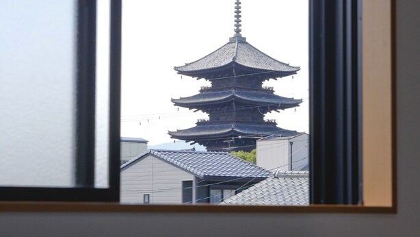 Una habitación con un amplio ventanal que da a una pagoda japonesa tradicional.
