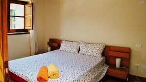 Une chambre à coucher avec un lit, une tête de lit en bois et une fenêtre avec des rideaux.