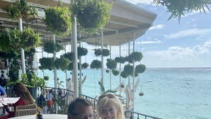 Ein Restaurant mit Terrassensitzgelegenheiten und Meerblick, mit hängenden Pflanzen und Blick auf den Ozean.