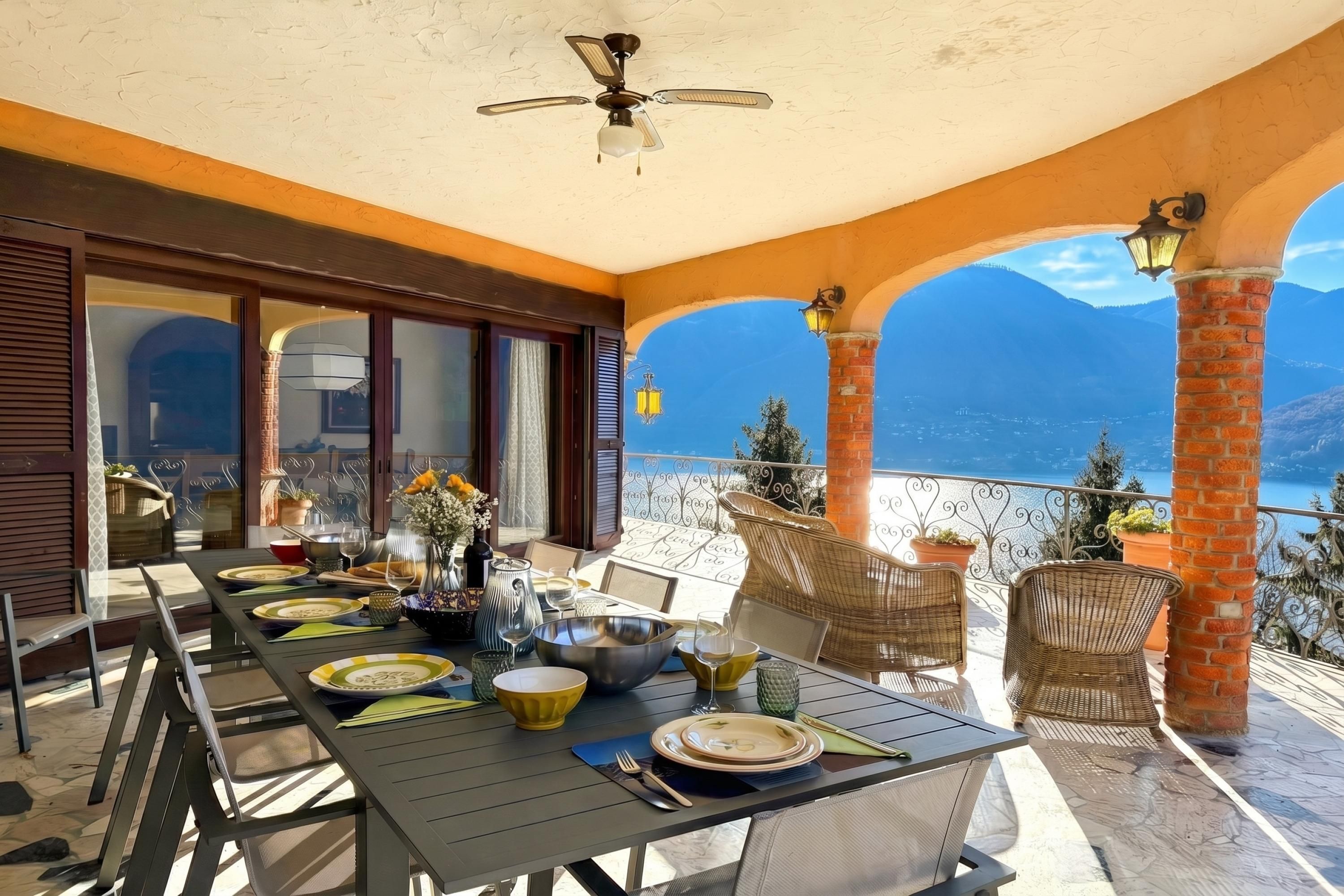 Ein Essbereich mit einem Tisch für vier Personen, einem Deckenventilator und Blick auf die Berge.