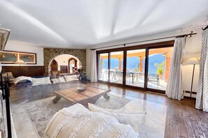 A spacious living area with a large sliding glass door leading to an outdoor terrace. - Villa Isola Verde, Valsolda, Italy (Valsolda)