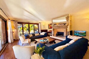 A living room with a fireplace, a sofa set, a coffee table, and a television. - Villa Isola Verde, Valsolda, Italy (Valsolda)