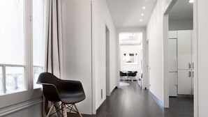 Un interior moderno con un pasillo largo, un comedor y una cocina.