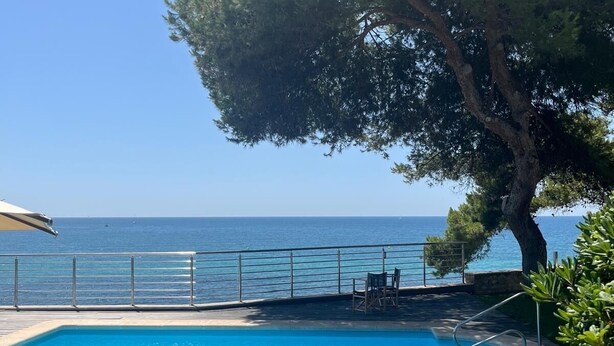 A pool area with a view of the sea, a tree, and outdoor furniture. - Wonderful Villa, private pool, seafront, garden, excellent views to the bay (Playa Albufereta- Alicante)