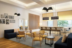 A modern hotel lobby with a sofa, chairs, a dining area, artwork on the walls, and pendant lighting. - City Express By Marriott Osaka Namba South (Osaka)