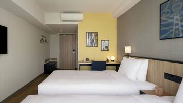 Une chambre d’hôtel avec deux lits, un bureau, une chaise, une lampe et une œuvre d’art accrochée au mur.