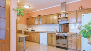 Une cuisine avec des meubles de rangement en bois, un four à micro-ondes, une cuisinière et un évier.
