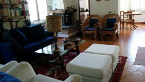 A living room with a sofa, two armchairs, a coffee table, and a bookshelf filled with books. - SPLENDID VIEW OF LAKE COMO bellagio / civenna (Civenna)