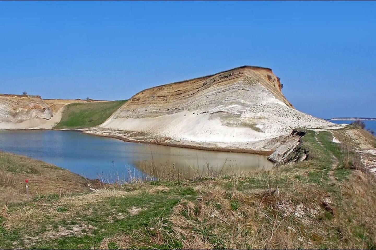 A coastal landscape with a large cliff and a body of water.