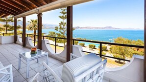 A balcony with a view of the sea, white furniture, and a wooden ceiling. - Family Beachfront Villa w/Private Pool & Play Area (Rethymno)