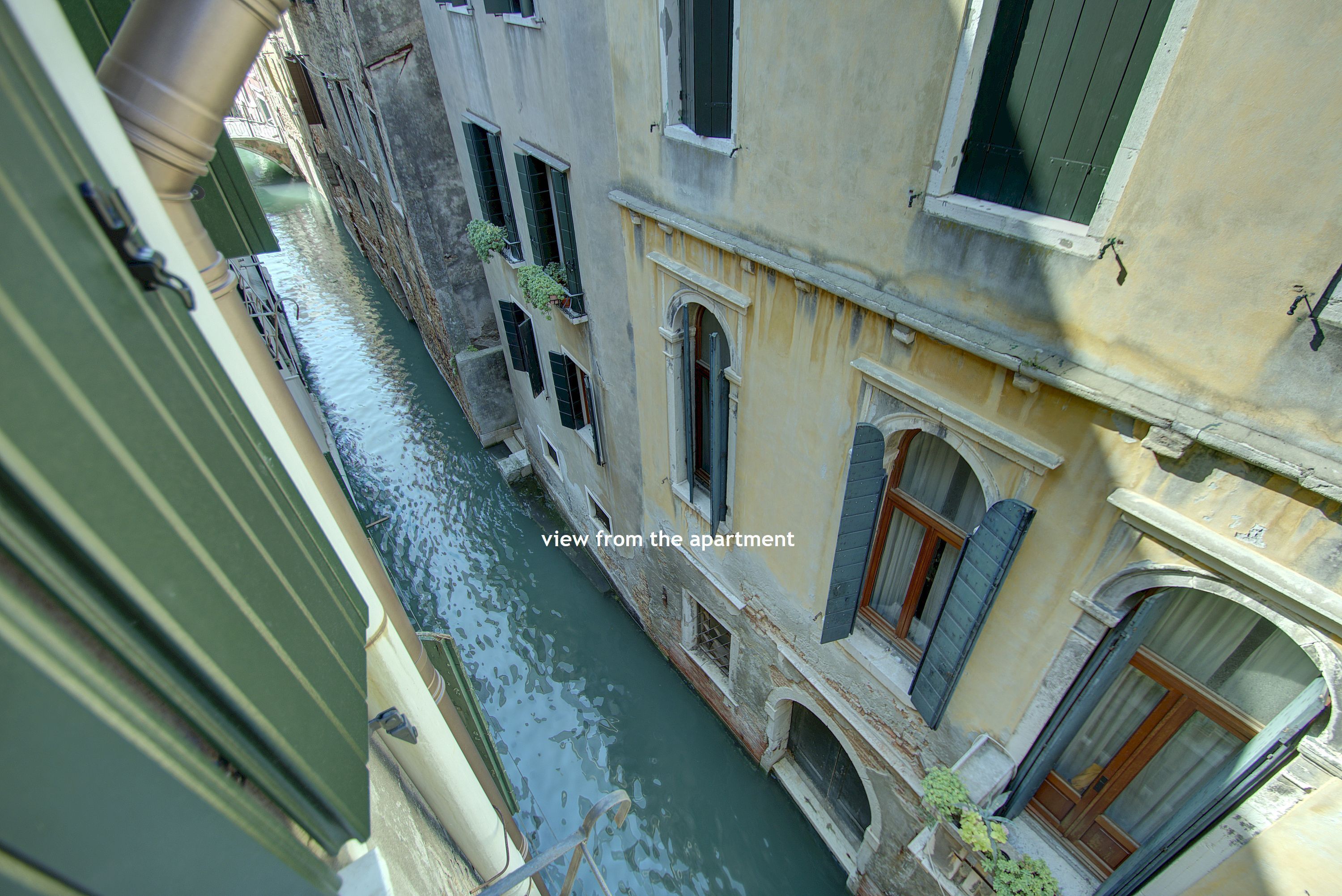 Un canale stretto con edifici su entrambe le sponde, vista da un appartamento con vista sull'acqua.