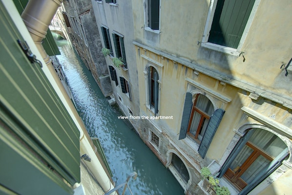 A narrow canal with buildings on either side, a view from an apartment overlooking the water. - RECIOTO Rialto~Market (Venezia)