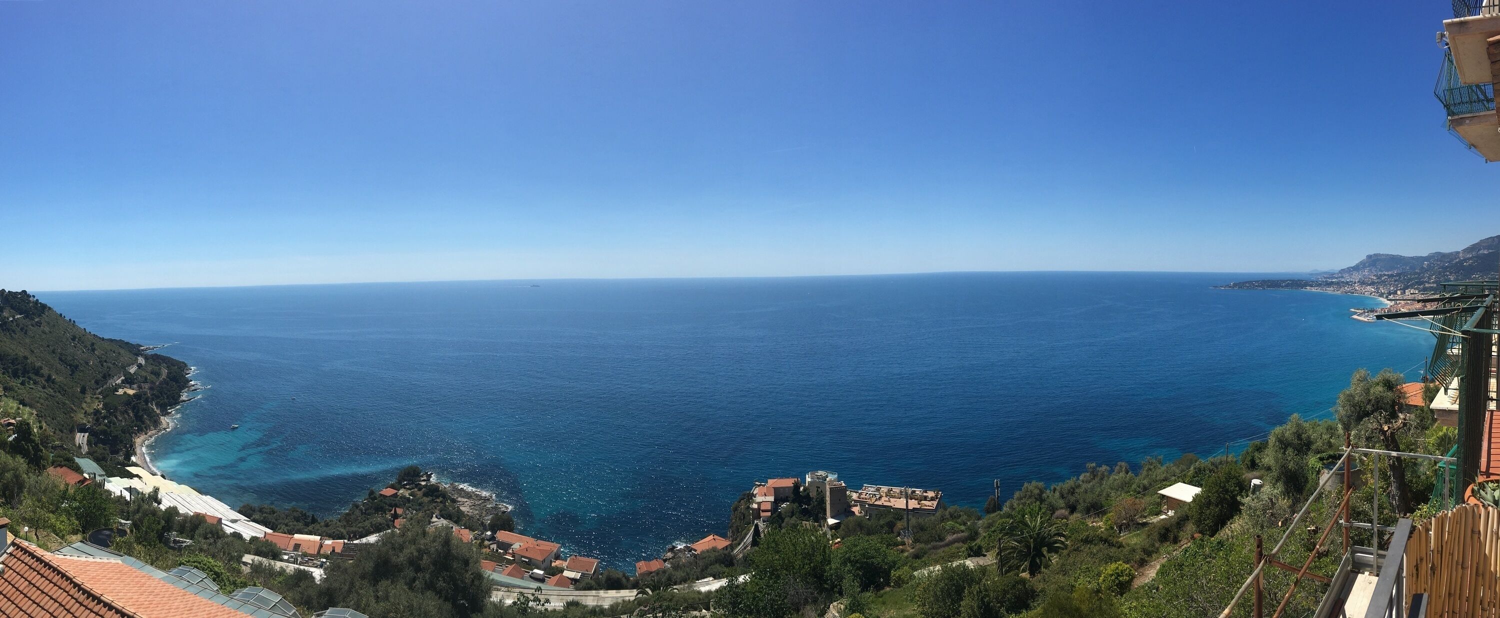 Une vue sur la côte, avec un ciel dégagé, une plage et des bâtiments le long du littoral.