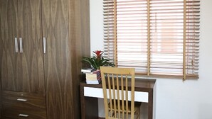 A room with a wooden wardrobe, a desk, and a chair. - V House 1 Serviced Apartment (Hanoi)