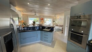 A modern kitchen with a central island, built-in oven, and stainless steel appliances. - 3 Bed Villa with Private Pool, West Coast Barbados (Porters St James)