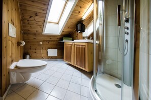 Een bad/douchecombinatie, een haardroger, handdoeken