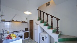 Una cucina con lavatrice, fornello e lavandino.