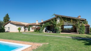 Ein Haus mit Swimmingpool, Terrasse und Garten.