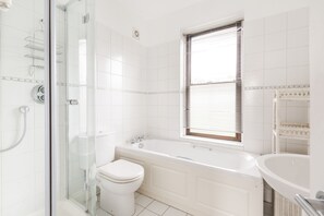 Een bad, een haardroger, handdoeken, toiletpapier