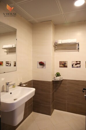 A bathroom with a sink, mirror, and towel rack.