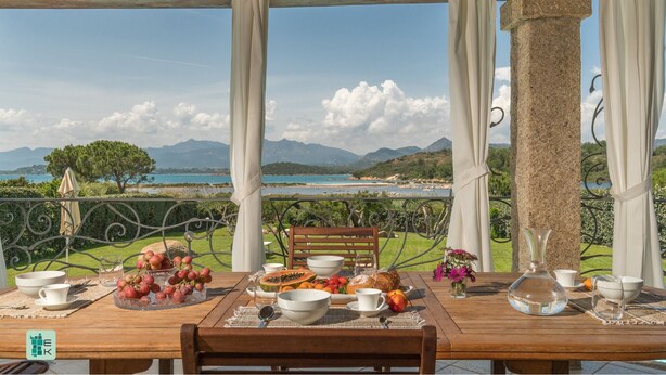 Une table dressée pour le petit-déjeuner, avec une vue imprenable sur un lac et des montagnes.