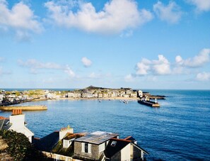 Experience the charm of a compact coastal town with traditional and modern architecture, situated along the waterfront with a prominent pier.